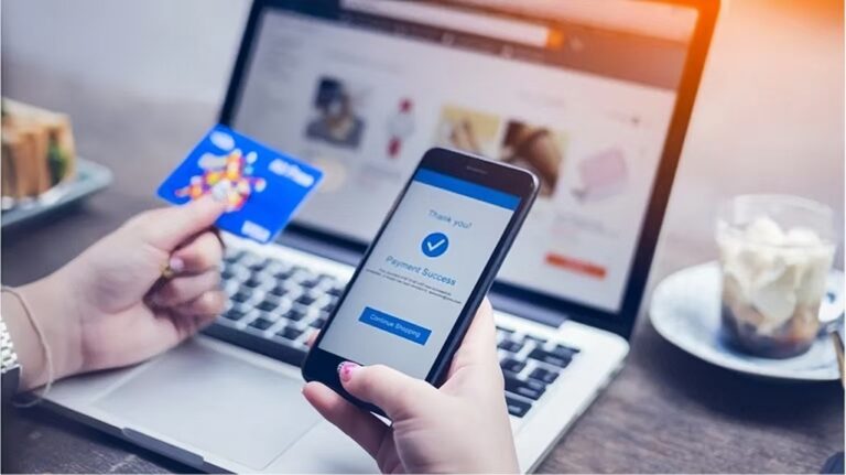 Online payment: person holding a credit card and phone showing “Payment Success.”